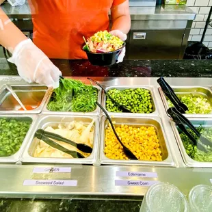 a person preparing food in a buffet