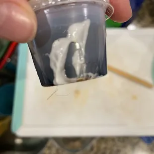 a hand holding a small container of food