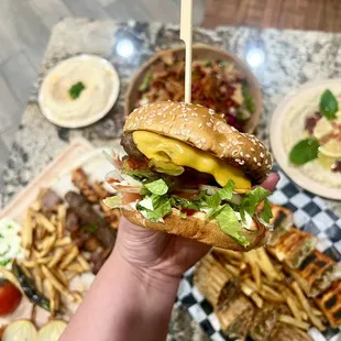 a hand holding a hamburger