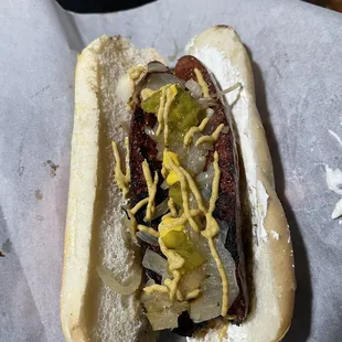 a hot dog with pickles and mustard