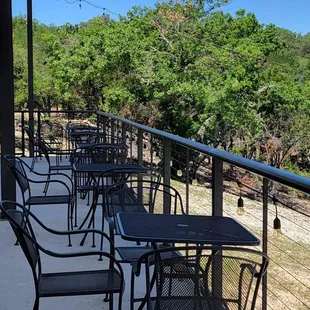 a balcony with tables and chairs
