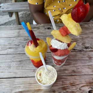 a man sitting at a table with fruit and ice cream