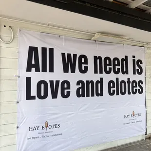 Cute sign outside in the seating area, picnic tables are available.