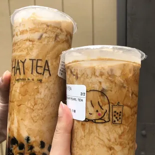 a hand holding two cups of tea