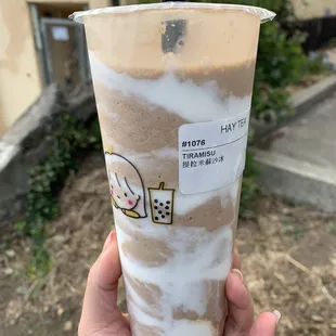 a hand holding a cup of iced coffee