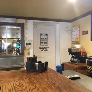a counter with a coffee maker and coffee cups on it
