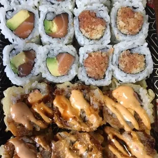 Spicy tuna roll, salmon avocado roll, and bagel roll with extra sauce.