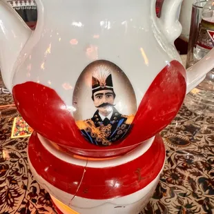 a teapot with a picture of a man on it