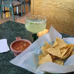 a bowl of chips and a drink
