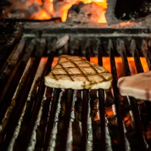 a burger being cooked on a grill