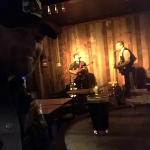 Small stage area - Ben Rice and Joshua Josué performing. Drinking a Stout from the refrigerator case.