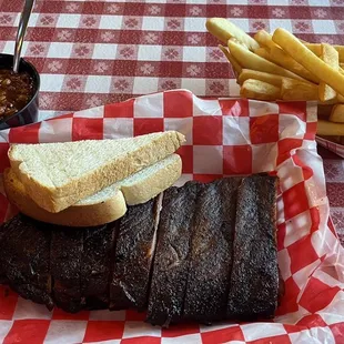 Half rack of ribs with bbq beans and fries.