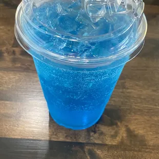 a blue drink in a plastic cup