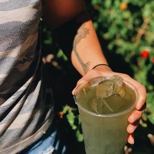 a person holding a drink in their hand