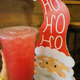a person holding a drink and a santa hat