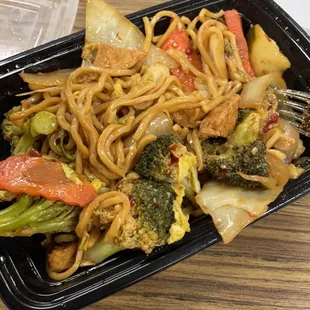 a takeout container with noodles and vegetables