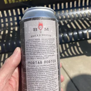 a hand holding a can of beer