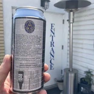 a hand holding a can of beer