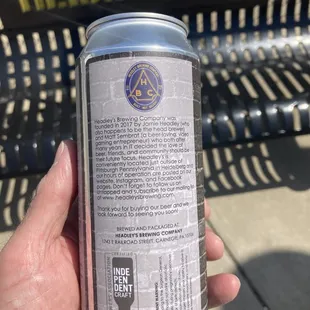 a hand holding a can of beer