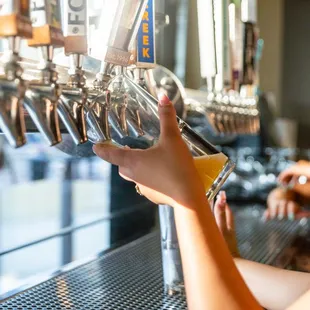 a woman filling a glass of beer