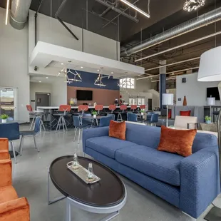 a blue couch and chairs in a large open space