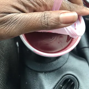 a person's hand holding a pink cup