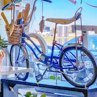 a blue bicycle and a basket of bread