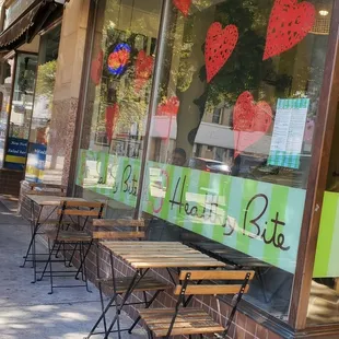 a row of tables and chairs in front of a store