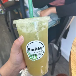 a person holding a glass of juice