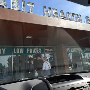 people walking in front of a grocery store