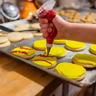 a person spreading icing on a cookie
