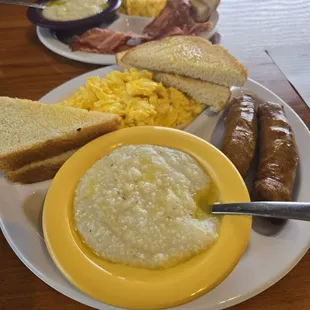 Sausage, Bacon,  Eggs with Cheese, Cheese grits, and Buttered  toast