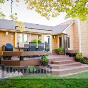 the back of a home with a deck and patio