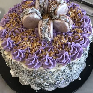 Lemon soak cake with lemon buttercream frosting, adorned with macarons and silver sprinkles