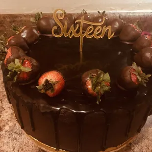 Rich chocolate cake covered in dark chocolate frosting accented with fresh chocolate dipped strawberries