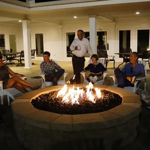 a group of people sitting around a fire pit