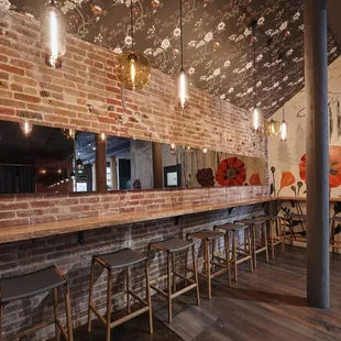 a brick bar with stools and mirrors