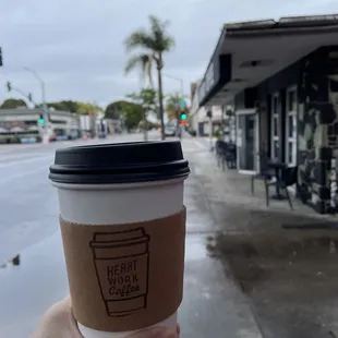 a hand holding a cup of coffee