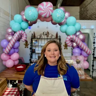 a woman standing in front of a balloon arch