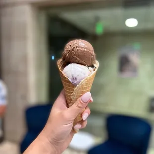 a hand holding an ice cream cone