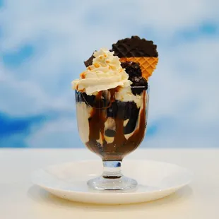 a chocolate sundae with whipped cream and a cookie