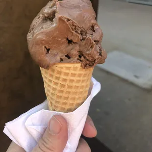 a hand holding a cone of ice cream