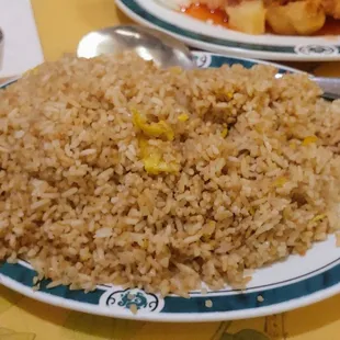 a plate of fried rice and a plate of fried chicken