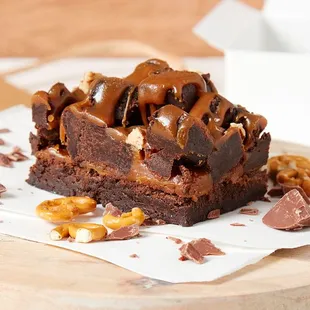 A light textured Brownie topped with buttery caramel, piled high with brownie cubes, toasted pecans and a caramel drizzle.