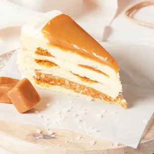 Light, buttery vanilla-flecked cake has waves of caramel cake and layered with salted caramel crunch and a creamy custard layer.