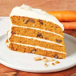 Layers of moist carrot cake with raisins, walnuts, pineapple, topped with cream cheese icing, &amp; a white chocolate ganache.