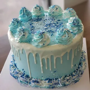 a frosted cake with blue icing and sprinkles