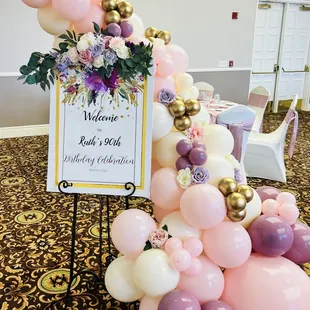 Welcome sign with balloon garland and floral decor