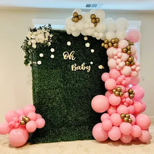 Ombré pink balloon garland with green hedge backdrop