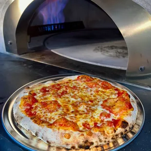 a pizza being cooked in a pizza oven